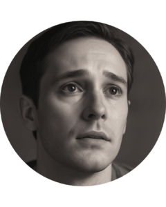 Black and white image. Shows a close-up of the face of an attractive man, looking sad, almost desperate.